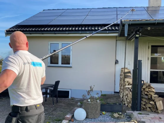 Solcellevask Professionel rensning af solceller med kalkfrit vand. Medarbejder fjerner snavs og kalk fra solceller.