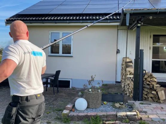Solcellevask Professionel rensning af solceller med kalkfrit vand. Medarbejder fjerner snavs og kalk fra solceller.